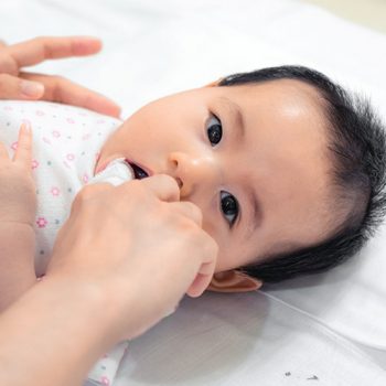 A baby playing, exploring and engaging with their surroundings.